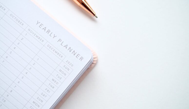 close up photo of yearly planner beside a pen